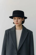 Black felt pork pie hat by Sbarià with a ribbon bow, waterproof and crushable wool felt for stylish weather protection.