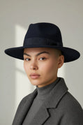 Black felt fedora hat with a ribbon bow by Sbarià, waterproof and crushable, shown on a model.