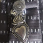 Close-up of Claudia De Rosa Jewelry Urban Warrior Cravatta Gioiello with a detailed sacro cuore charm on the necklace.