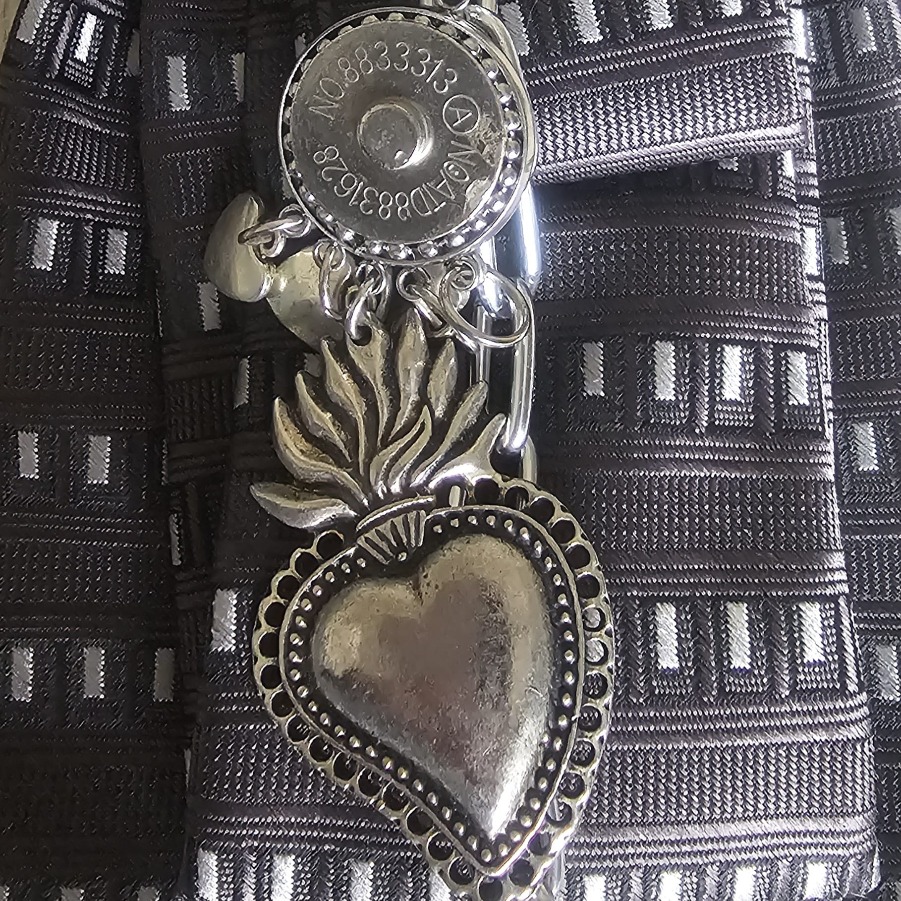 Close-up of Claudia De Rosa Jewelry Urban Warrior Cravatta Gioiello with a detailed sacro cuore charm on the necklace.