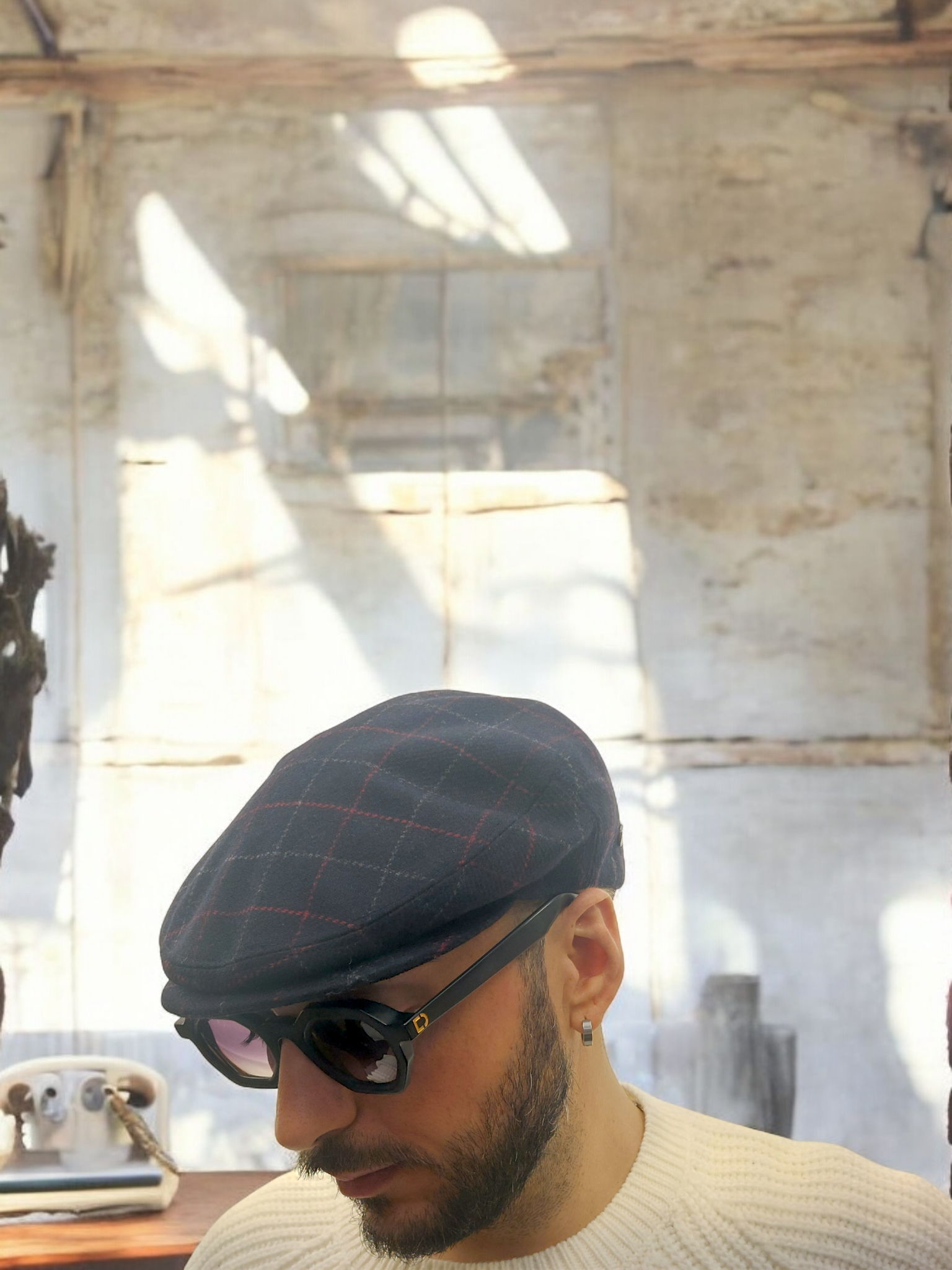 Autunno/Inverno Coppola in pura lana vergine nera with subtle gray and red plaid pattern, stylish and warm accessory.