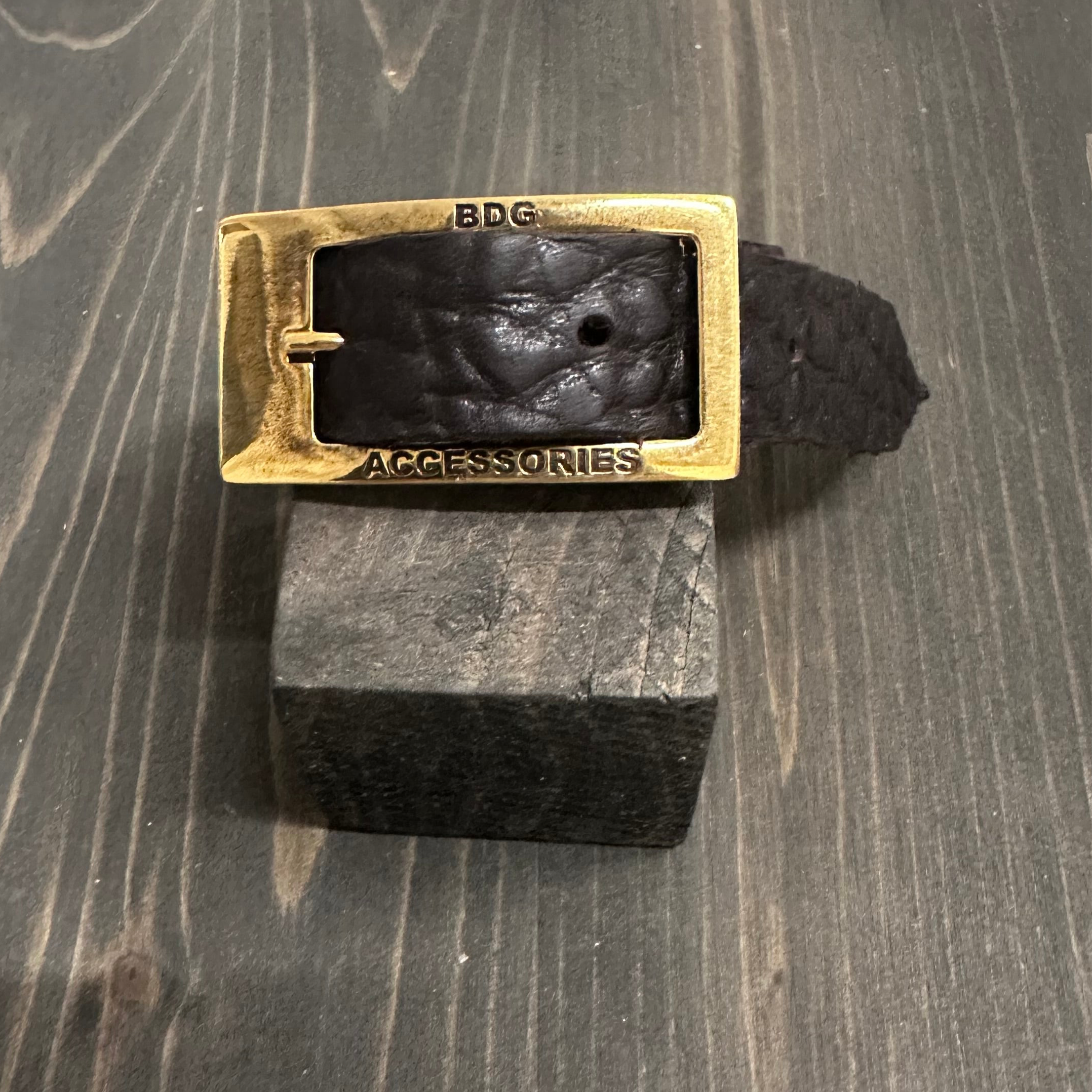 BDG Accessories leather bracelet in old style with rustic design, displayed on a wooden block.