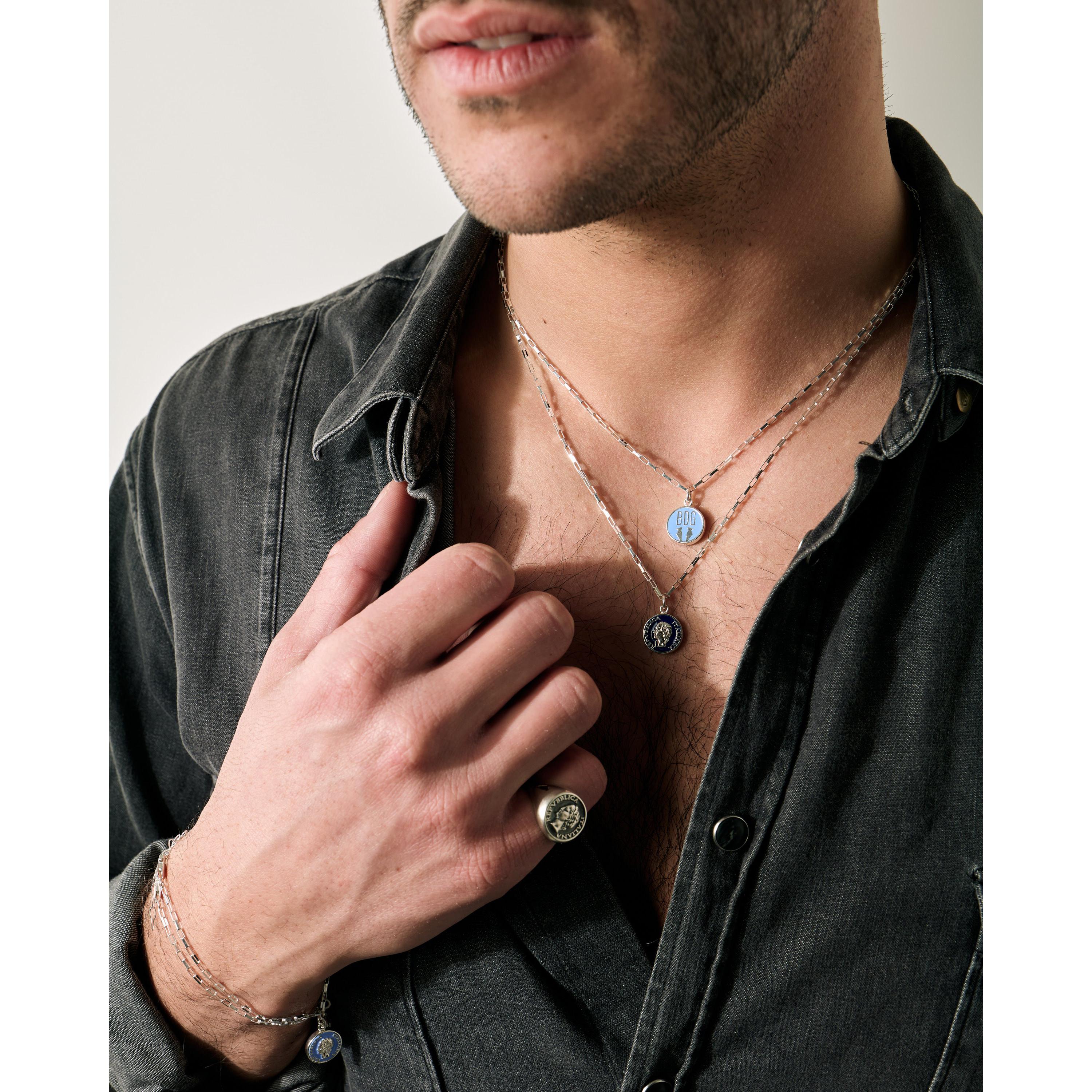 Silver enamel necklace with vintage 1950s Dolce Vita style from BDG Accessories, worn on a man's hand.