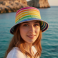 Modella con bucket hat ribbon multicolor, pin sinistra, Lampedusa