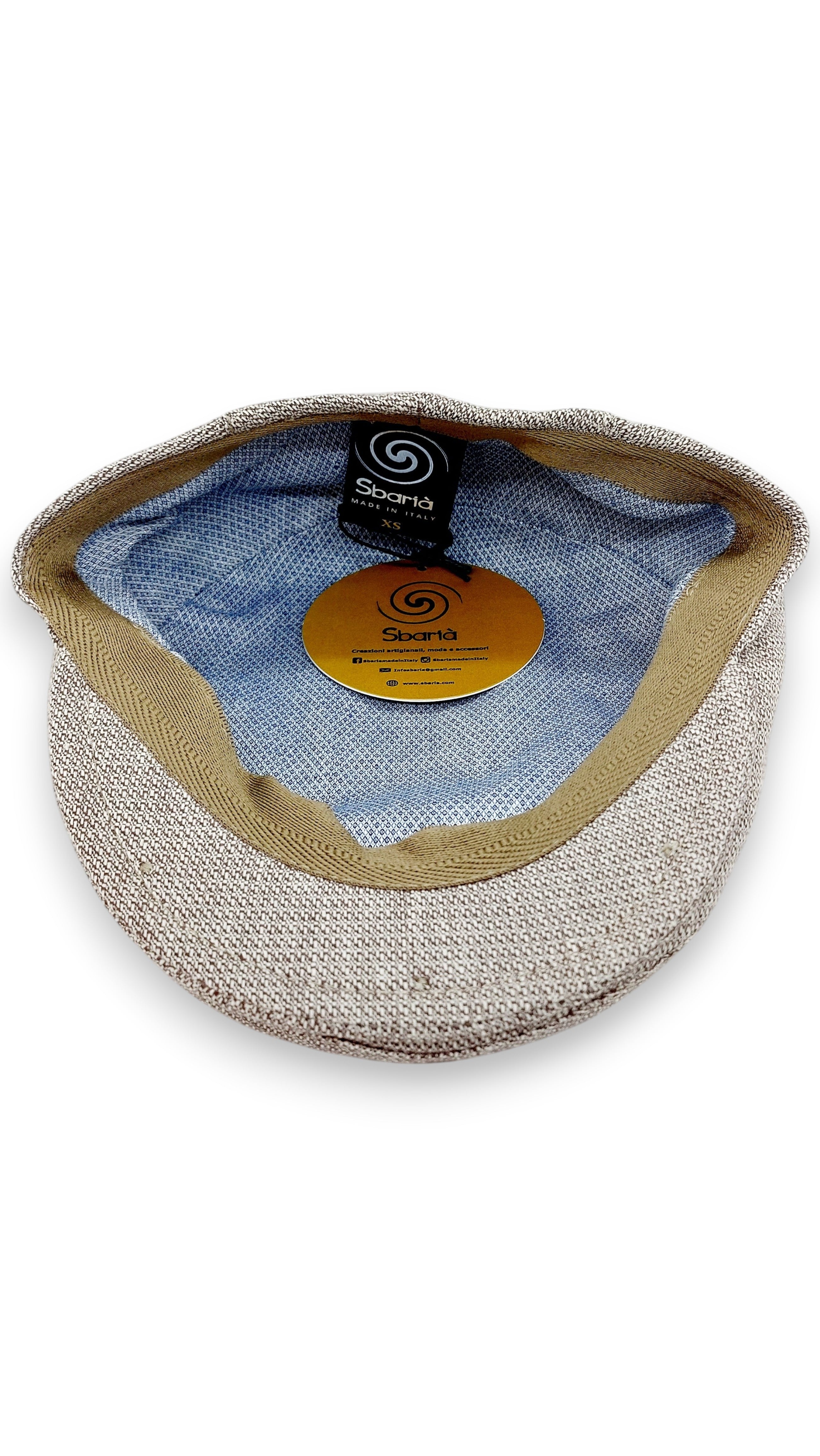 Sbarià beige linen and cotton flat cap with a subtle micro-pattern and tan trim. Interior is light blue with a patterned lining.