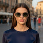 Modella indossa occhiali da sole rotondi Sbarià Catania con montatura in alpacca e lenti scure in stile vintage