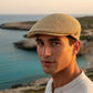 Sbarià natural raffia crochet flat cap for men, handwoven with a textured finish.